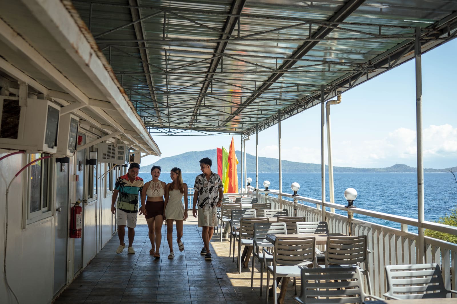 Guests walking along the sea-view deck at Isola Vista Beach Resort